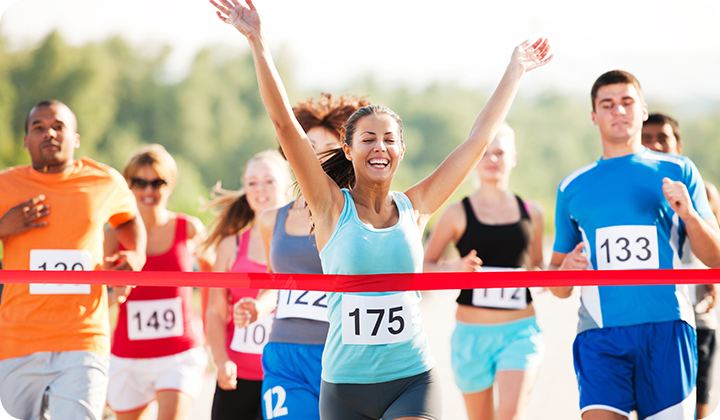 Frau läuft durch Ziel Triathlon Training